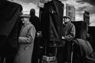 摄影师拍摄英国赛马场上的 赌徒 