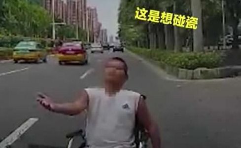 太猖狂 男子坐着轮椅在马路上碰瓷,竟逼停车辆上前伸手要钱