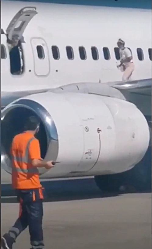 太热了,乌克兰女子打开飞机紧急出口,淡定走到机翼上吹风