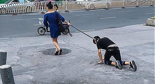 合肥街头一男子被女子牵绳跪行,如同 遛狗 ,路人围观拍照
