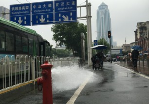 路边消防栓爆裂狂喷水 小伙子平静地坐在桶罩上走红(消防栓爆裂是什么部门管的)